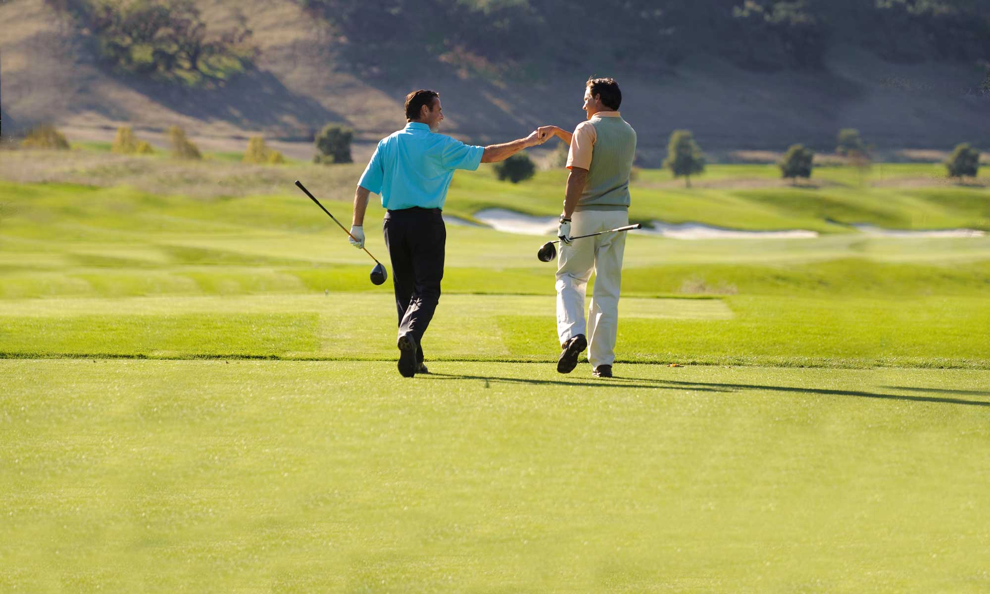 Two men shaking hands on their corporate golf day.