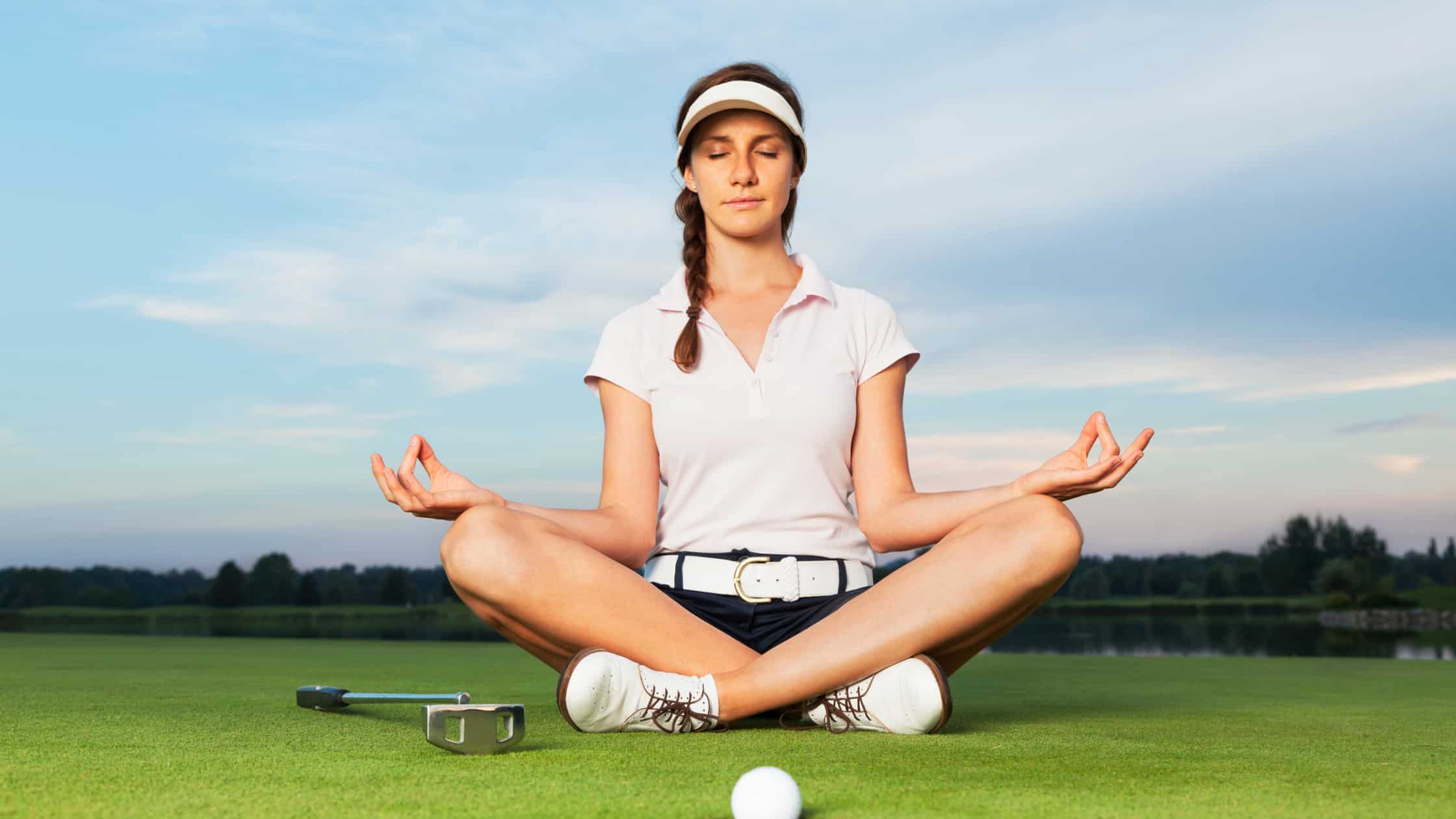 Woman meditating on the golf course
