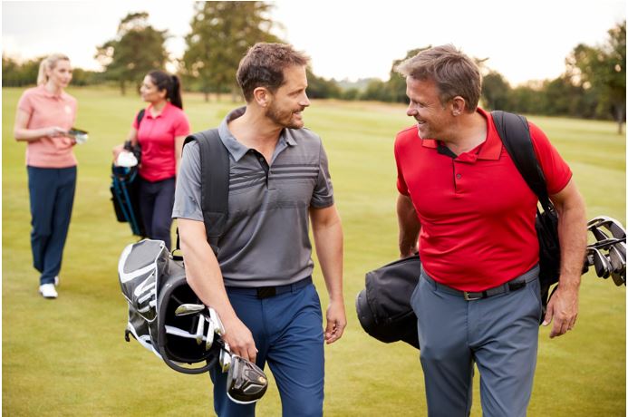 Two men talking on a golf course